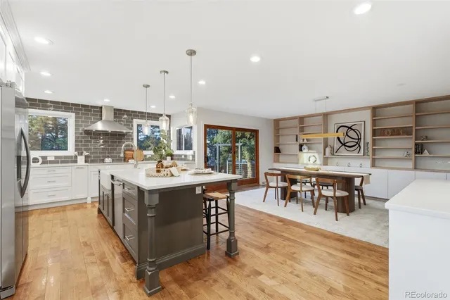 a large kitchen with lots of furniture a sink appliances and a dining table
