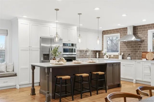 a kitchen with stainless steel appliances granite countertop a sink and a refrigerator