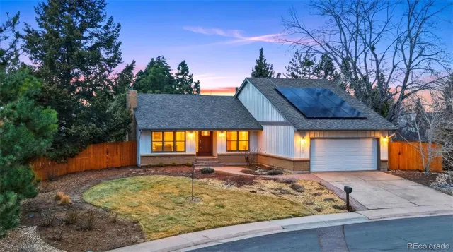a view of a house with a large tree and a yard