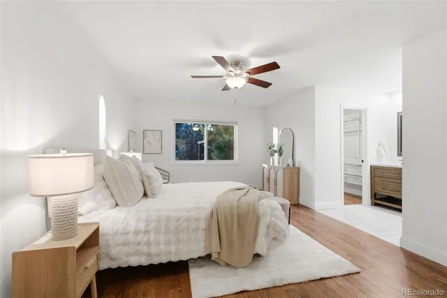 a bedroom with a bed a mirror and lamp