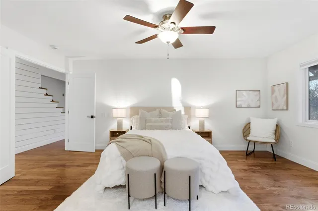 a bed room with a bed a chair and a potted plant