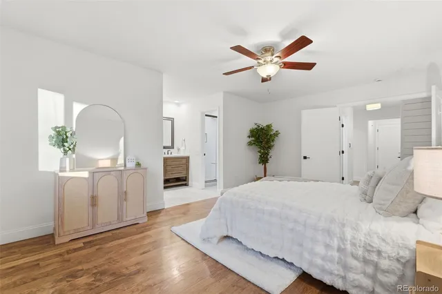 a spacious bedroom with a large bed a chandelier and windows