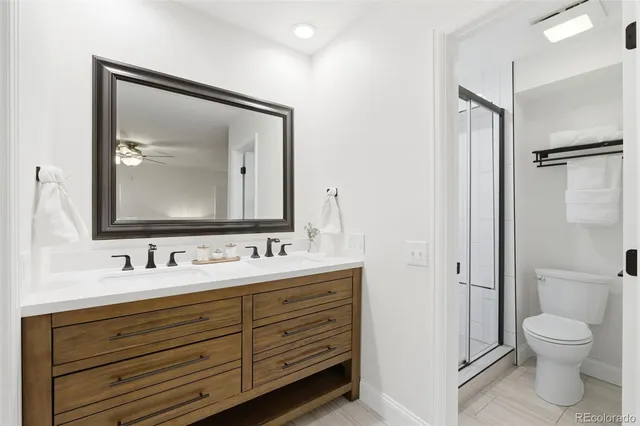 a bathroom with a toilet sink double vanity and a mirror