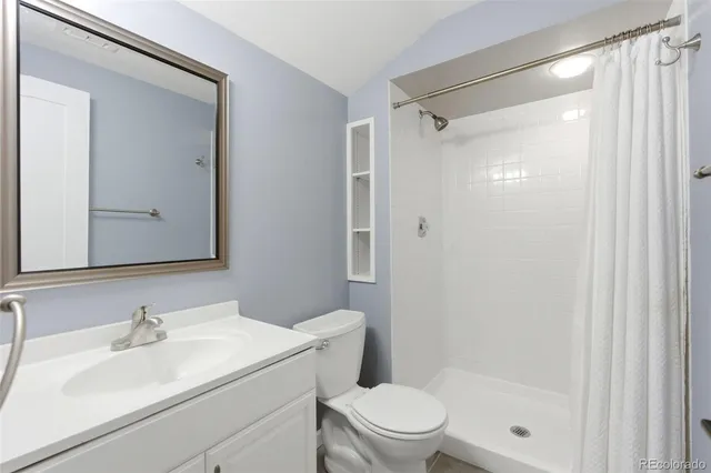 a bathroom with a sink toilet vanity and shower