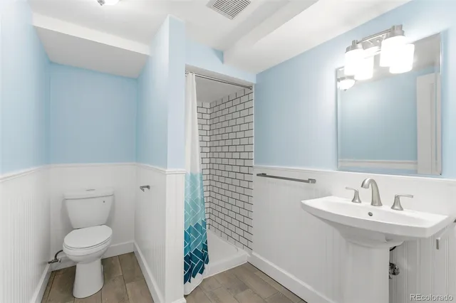 a bathroom with a sink a toilet and shower