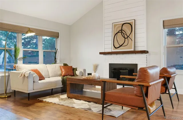 a living room with furniture a fireplace and a large window