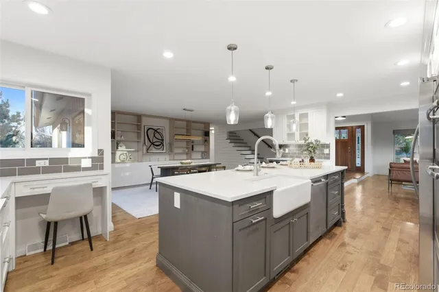 a large kitchen with kitchen island a sink a stove a dining table and chairs