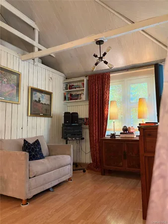 a living room with furniture a flat screen tv and floor to ceiling window