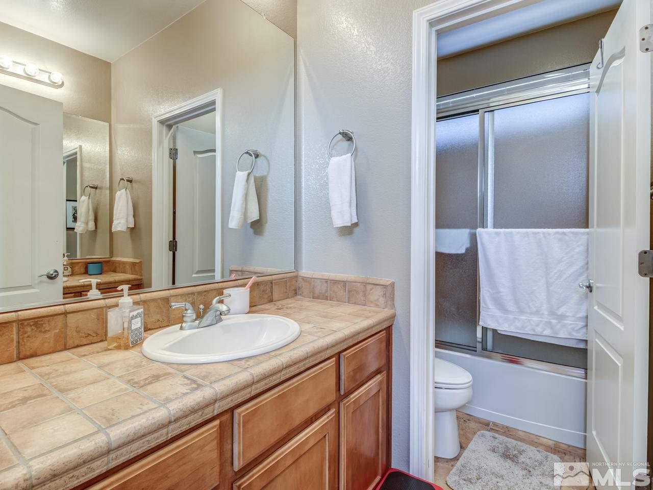 560 Secretariat Court Reno, NV 89521 - Photo 16 of 25 a bathroom with a granite countertop sink a toilet and shower