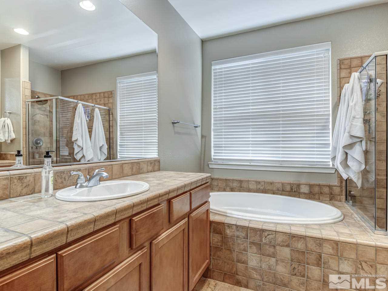 560 Secretariat Court Reno, NV 89521 - Photo 18 of 25 a bathroom with a granite countertop sink and a mirror