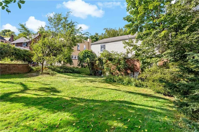 a view of a house with a yard and potted plants