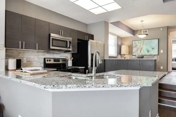 a kitchen with kitchen island granite countertop a stove and a sink