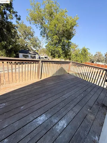 a view of a room with wooden floor and a ceiling fan