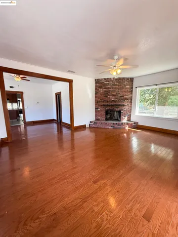 a view of an empty room with window and fire place