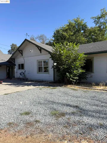 a white house that has a tree in front of it