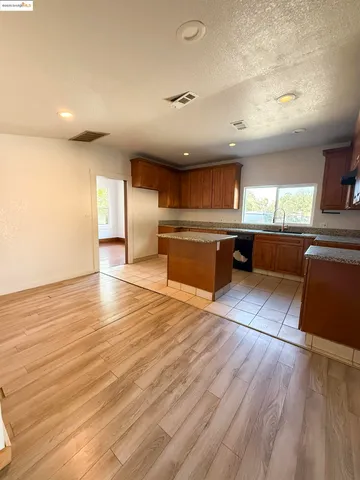 a large kitchen with stainless steel appliances granite countertop a sink and cabinets