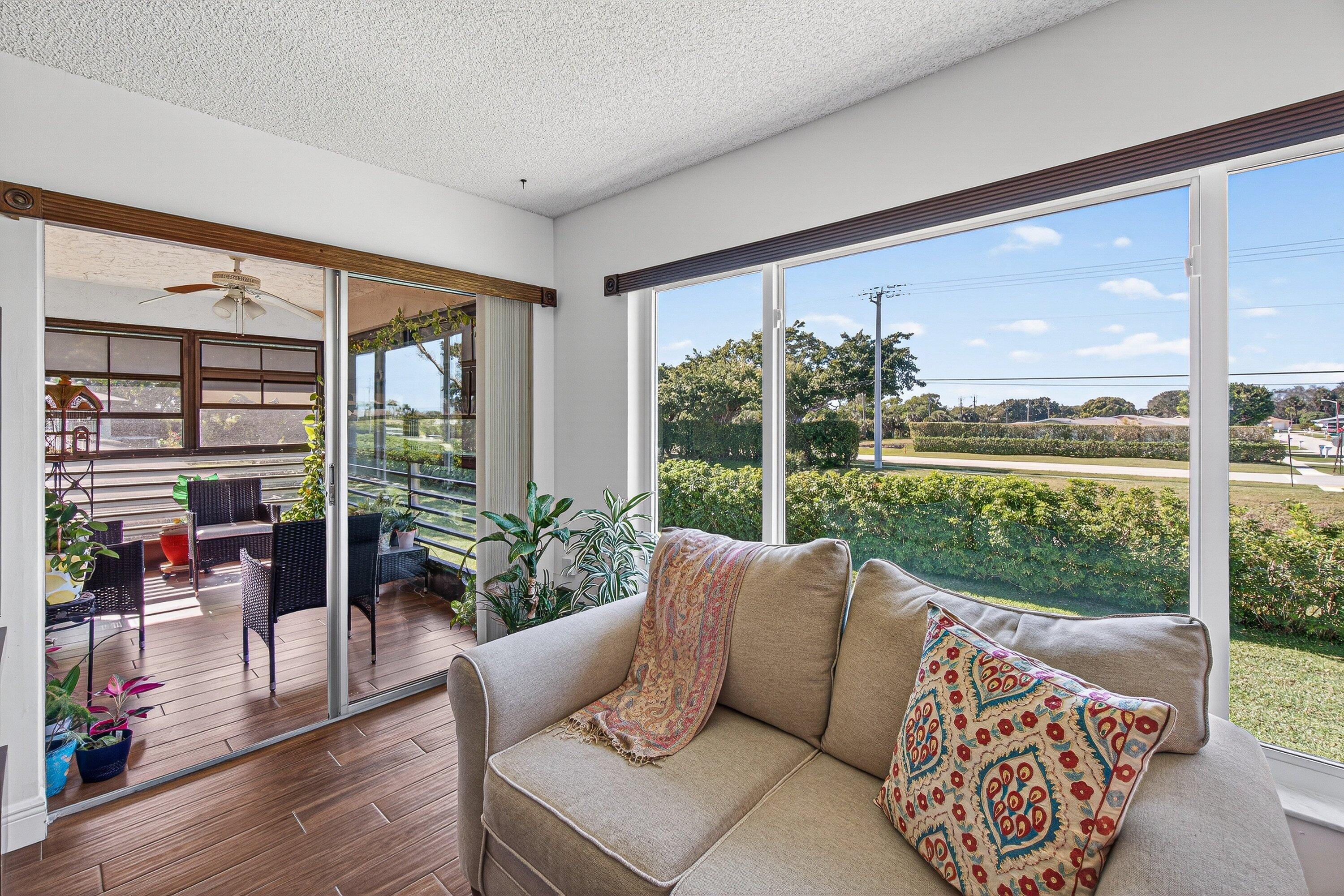 13465 Fishtail Palm Court, Unit D Delray Beach, FL 33484 - Photo 21 of 29 a living room with furniture and floor to ceiling windows
