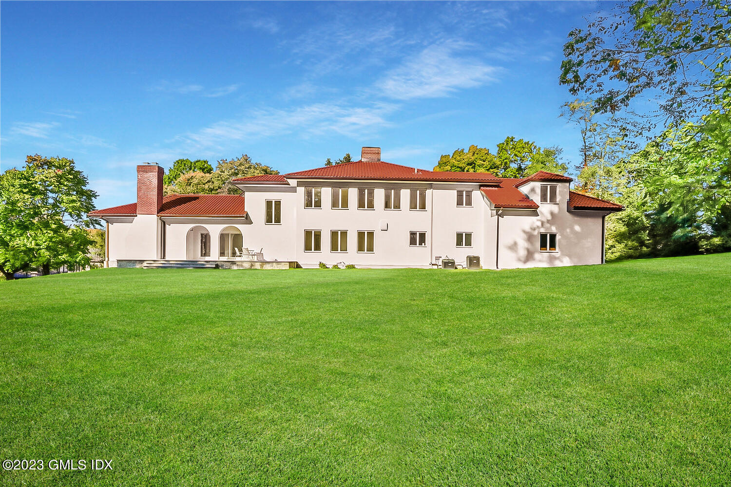 10 Harkim Road Greenwich, CT 06831 - Photo 2 of 39 a view of a white house with a big yard and large trees