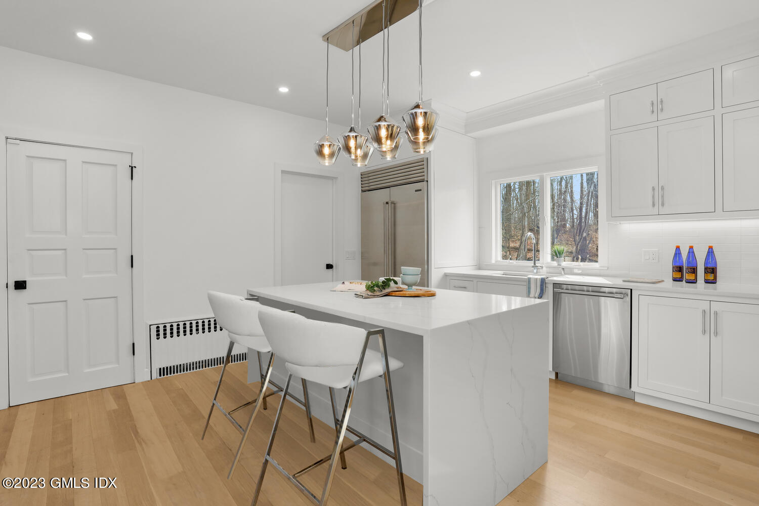 10 Harkim Road Greenwich, CT 06831 - Photo 5 of 39 a kitchen with kitchen island a sink stove and white cabinets with wooden floor