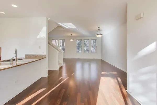 a hallway with wooden floor table and chairs