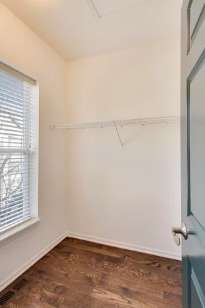 a view of a room with wooden floor and small window