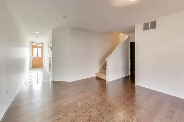 a view of a hallway with wooden floor and stairs