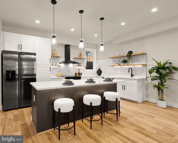 a kitchen with stainless steel appliances granite countertop a stove a sink dishwasher a refrigerator with white cabinets and wooden floor