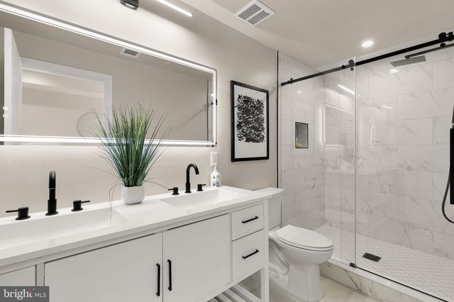 a bathroom with a sink a toilet a glass door shower and mirror