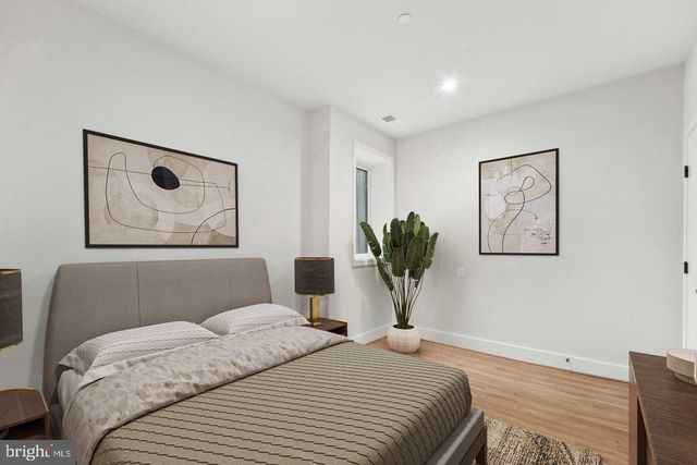 a bedroom with a bed and a painting on the wall