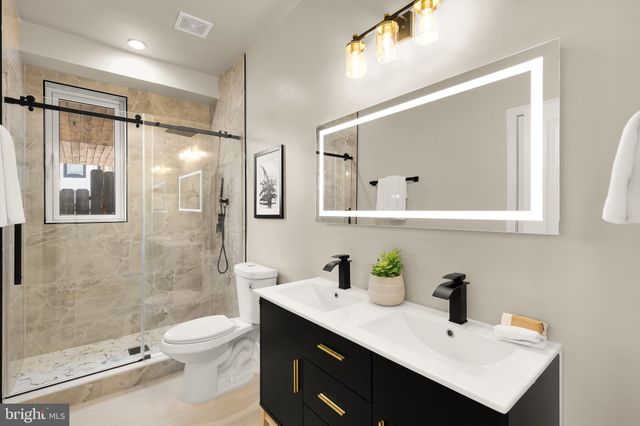 a bathroom with a sink toilet a mirror and shower