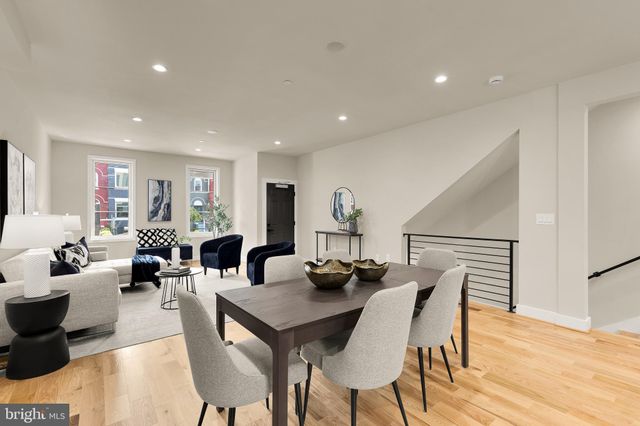a living room with furniture a wooden floor and a potted plant
