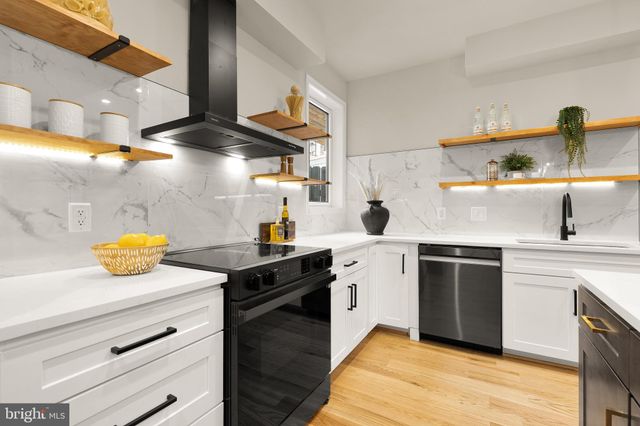 a kitchen with stainless steel appliances a stove a sink and cabinets