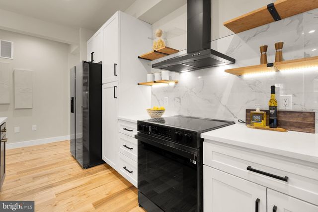 a kitchen with stainless steel appliances kitchen island granite countertop a refrigerator and a sink