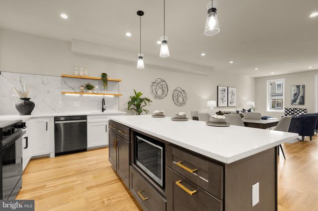 a kitchen with a stove a sink a kitchen island with wooden cabinets