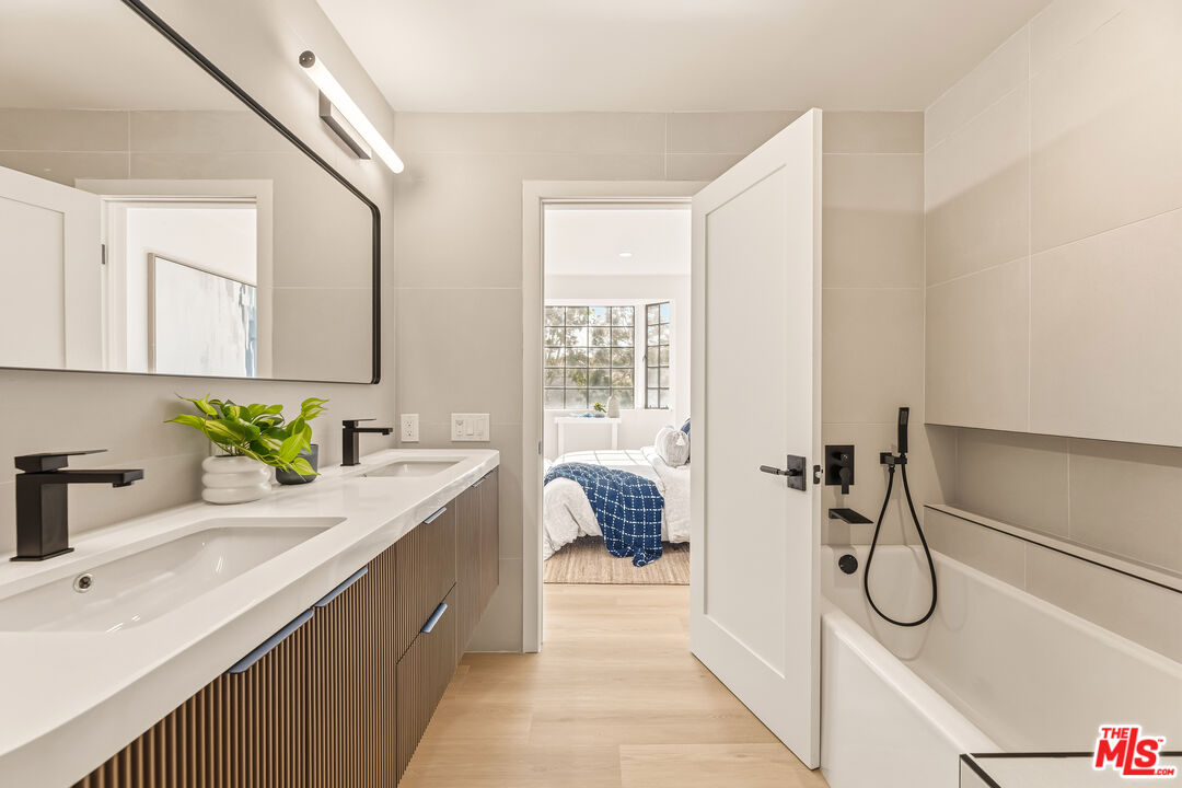 311 Bora Bora Way, Unit 3207 Marina del Rey, CA 90292 - Photo 25 of 54 a bathroom with a granite countertop sink vanity mirror bathtub and next to a window