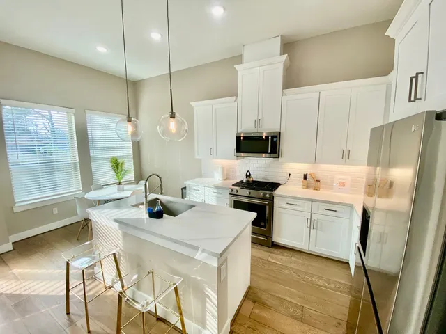 a kitchen with a sink a stove a refrigerator and cabinets