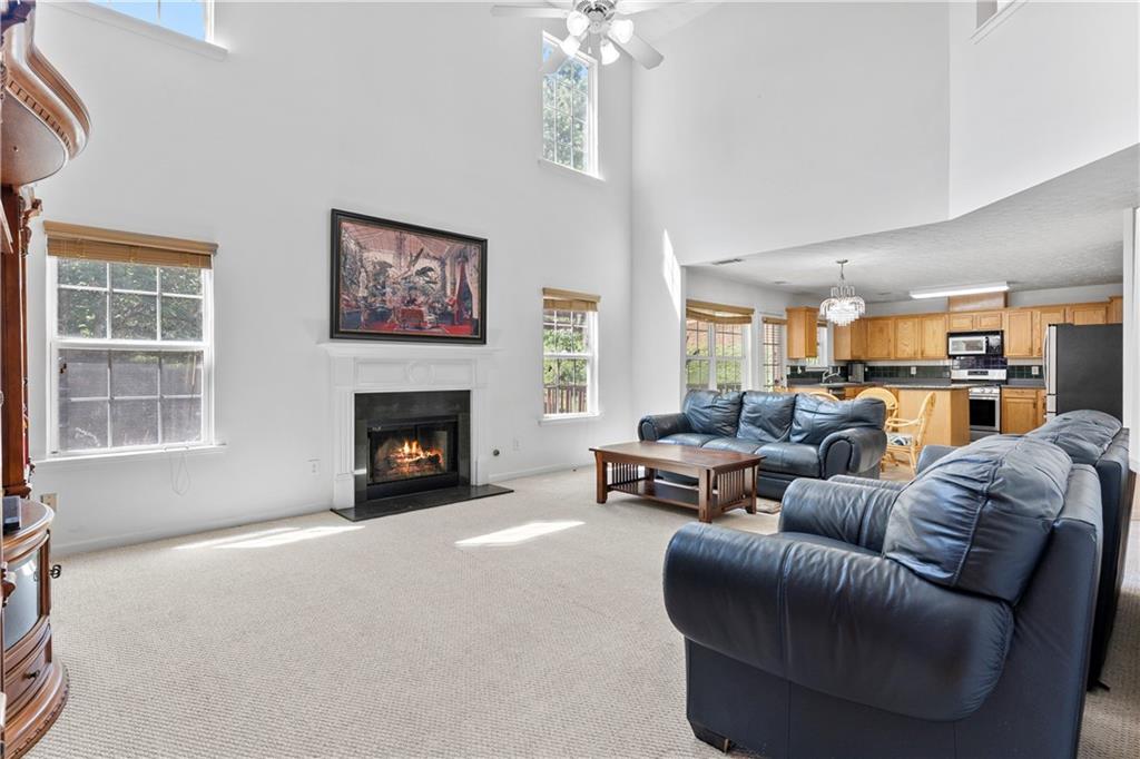 665 Roxford Lane Northeast Buford, GA 30518 - Photo 7 of 29 a living room with furniture a fireplace and a large window