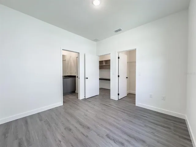 an empty room with wooden floor and closet