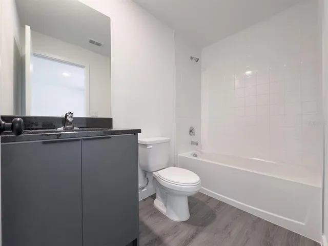 a bathroom with a granite countertop toilet and sink