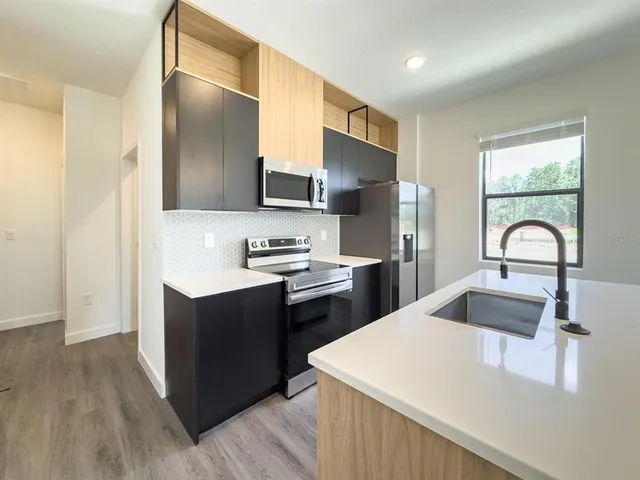 a kitchen with kitchen island a sink appliances and cabinets