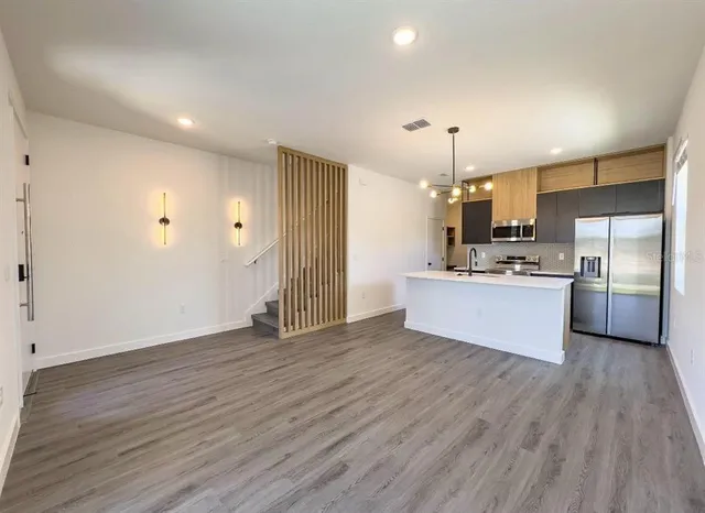a view of kitchen with granite countertop cabinets and refrigerator
