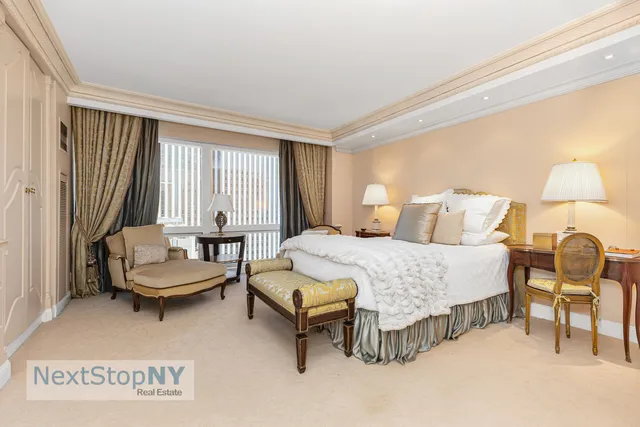 a bedroom with a large bed and a flat tv screen on dresser