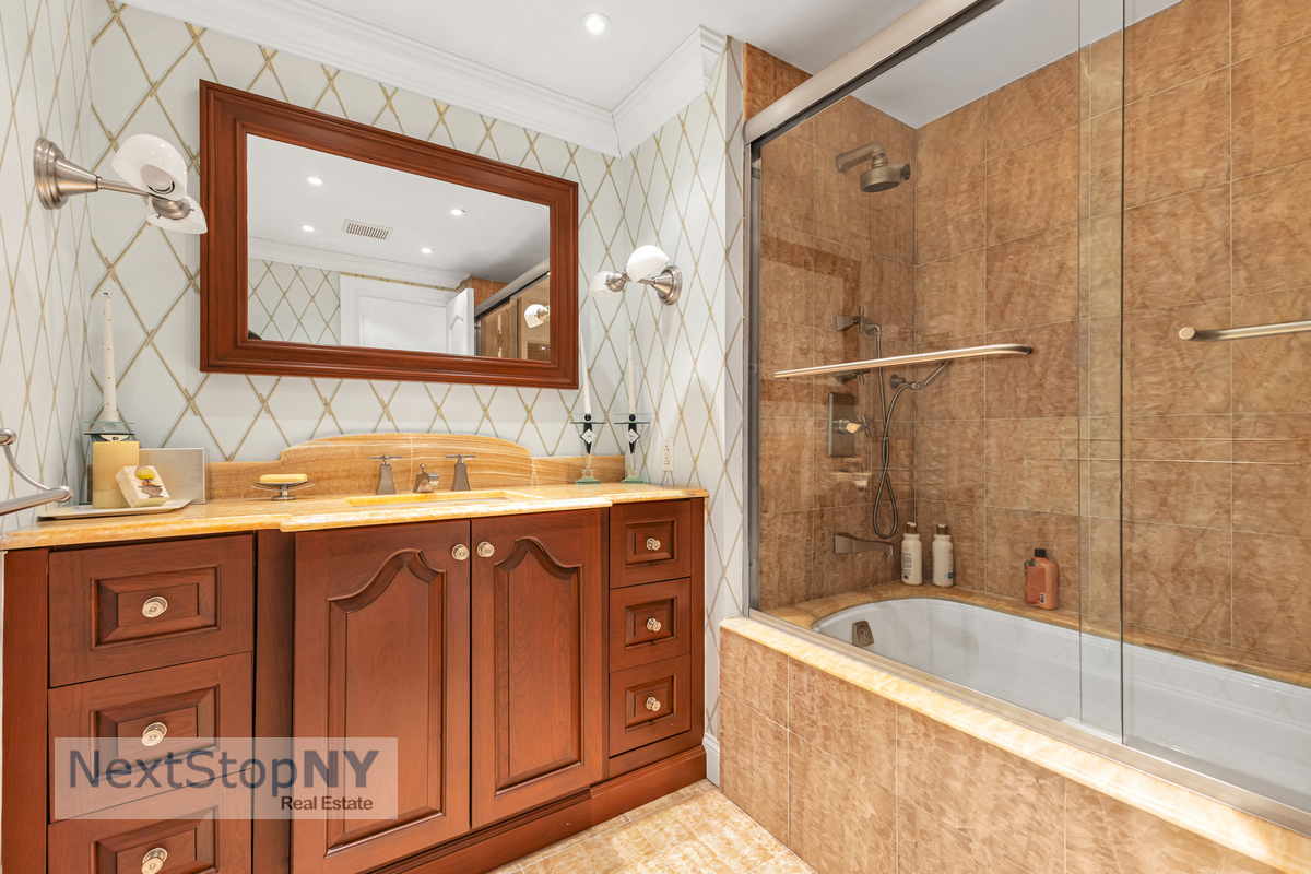 721 5th Avenue, Unit 48K Manhattan, NY 10022 - Photo 10 of 15 a bathroom with a tub a sink and mirror