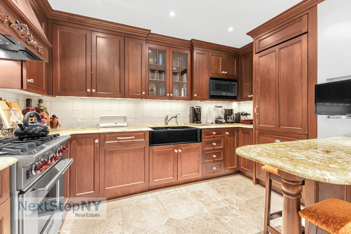 721 5th Avenue, Unit 48K Manhattan, NY 10022 - Photo 3 of 15 a kitchen with stainless steel appliances granite countertop wooden cabinets a stove top oven a sink and dishwasher