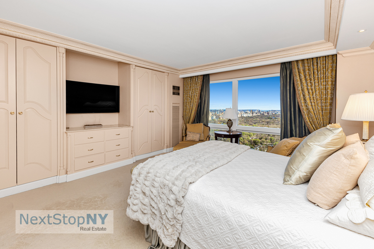 721 5th Avenue, Unit 48K Manhattan, NY 10022 - Photo 7 of 15 a bedroom with a large bed and a flat tv screen on dresser