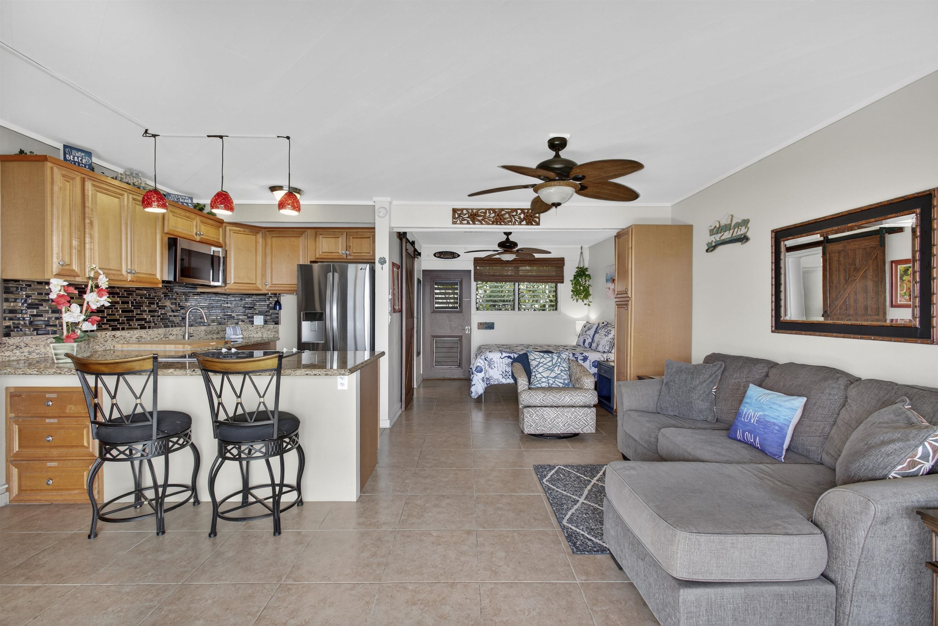 4435 Lower Honoapiilani Road, Unit 111 Lahaina, HI 96761 - Photo 33 of 50 a living room with furniture a fireplace and a flat screen tv