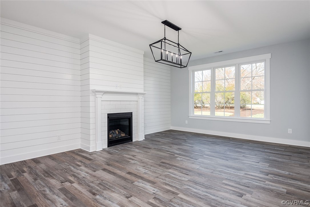 3154 Cider House Road Toano, VA 23168 - Photo 20 of 36 an empty room with windows fireplace and wooden floor