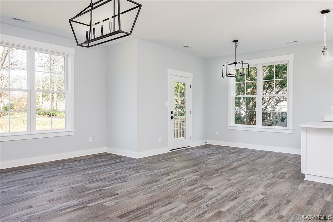3154 Cider House Road Toano, VA 23168 - Photo 21 of 36 an empty room with wooden floor chandelier and windows