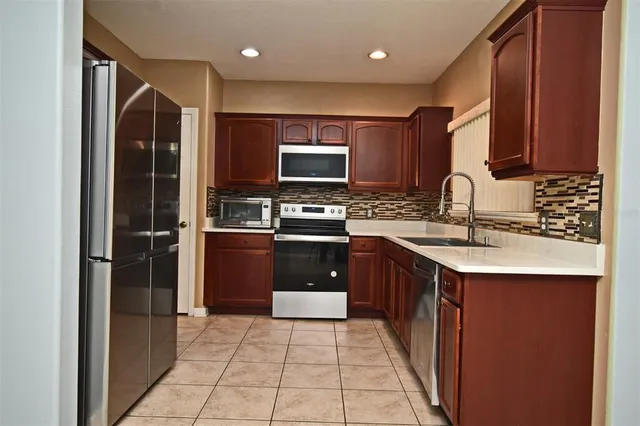 a kitchen with stainless steel appliances granite countertop a refrigerator and a sink