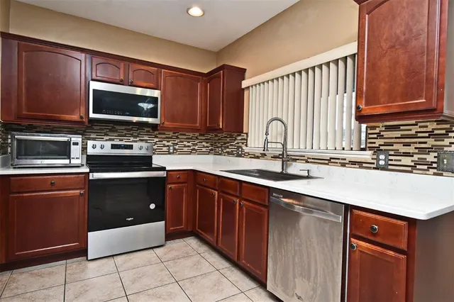 a kitchen with a sink stove top oven and microwave